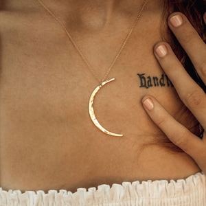 The Mystic Moon Necklace elevates celestial jewelry and beams with handcrafted quality.
Each moon pendant is hand forged by our team of women artists. The crescent moon is hand hammered with texture that mimics the look of the moon and measures 44mm