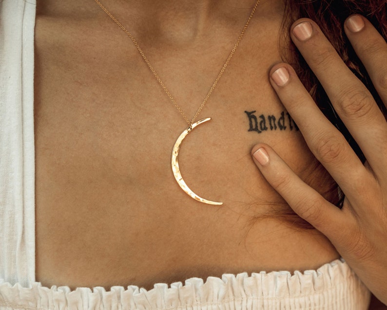 The Mystic Moon Necklace elevates celestial jewelry and beams with handcrafted quality.
Each moon pendant is hand forged by our team of women artists. The crescent moon is hand hammered with texture that mimics the look of the moon and measures 44mm