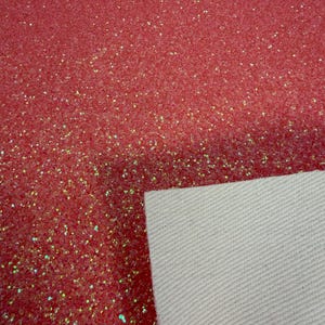 May include: Close-up of a sheet of red glitter fabric. The glitter is densely packed, creating a sparkling effect. The backing is a plain white canvas. This material is suitable for crafts and decorations.