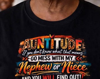 May include: Black t-shirt with the text "AUNTITUDE" in a colorful design. The shirt includes the phrases "If you don't know what that means... GO MESS WITH MY Nephew or Niece AND YOU WILL FIND OUT!"