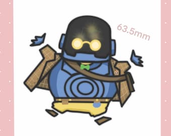 Könnte beinhalten: Illustration eines Cartoon-Roboters in Blau, Schwarz und Gelb, mit brauner Jacke und grüner Fliege. Der Roboter hat runde gelbe Gläser und den Text "63,5 mm" in Rosa.