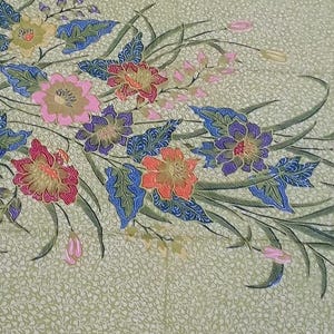 May include: A floral textile with a light green background and a detailed pattern of colorful flowers and leaves. The flowers are in shades of pink, red, orange, yellow, and purple, with blue and green leaves. The textile has a dark border.