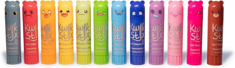 May include: A collection of colorful lip balms with bear-shaped caps and various facial expressions. Each balm has a different color, including gray, red, orange, yellow, green, blue, purple, pink, and brown. The text "Kwik Stix" is printed on each tube.