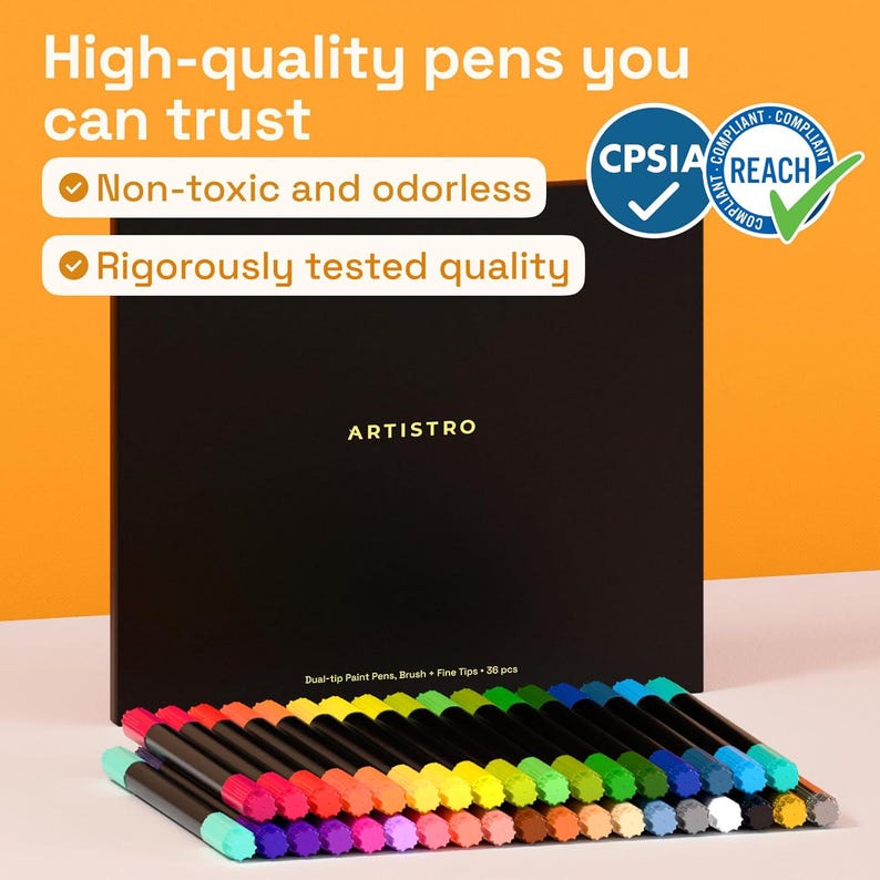 May include: A set of 36 dual-tip paint pens with brush and fine tips, arranged in a rainbow of colors. The pens are displayed in front of a black box with the brand name "ARTISTRO". The text "High-quality pens you can trust" is visible.