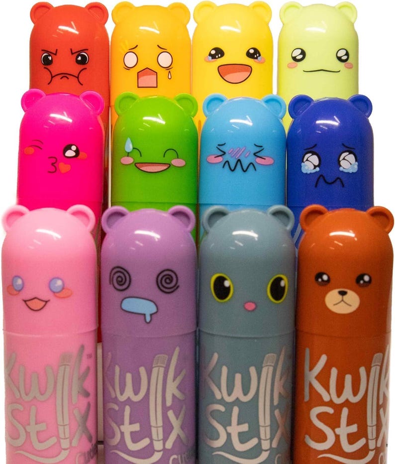 May include: A collection of colorful Kwik Stix paint sticks with bear-shaped caps, each displaying a different facial expression. The paint sticks are in various colors, including red, yellow, green, blue, pink, purple, gray, and brown. The text "Kwik Stix" is printed on the body of each stick.