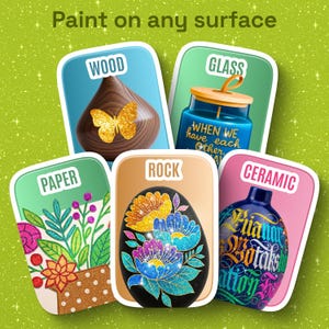 May include: A graphic display with the text Paint on any surface featuring five rectangular cards labeled Wood, Glass, Paper, Rock, and Ceramic. Each card shows a decorated object: a wooden shape with a gold butterfly, a blue glass jar, a floral paper design, a black rock with glitter flowers, and a blue ceramic vase with text.