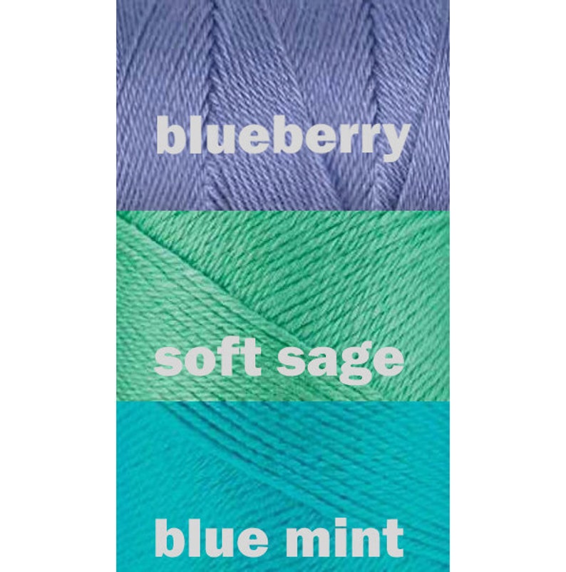 May include: Three skeins of yarn in different shades of blue and green. The top skein is a light blue color labeled "blueberry". The middle skein is a light green color labeled "soft sage". The bottom skein is a turquoise color labeled "blue mint".