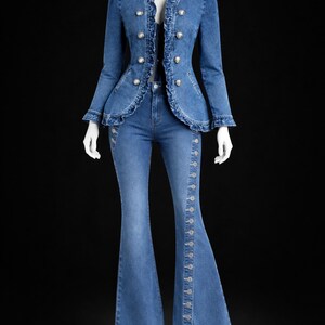 May include: A denim jacket and flared jeans set. The jacket has a ruffled collar and silver buttons. The jeans have a button detail down the side. The text "CRAFTSTUDIOBYMALIK" is at the top.