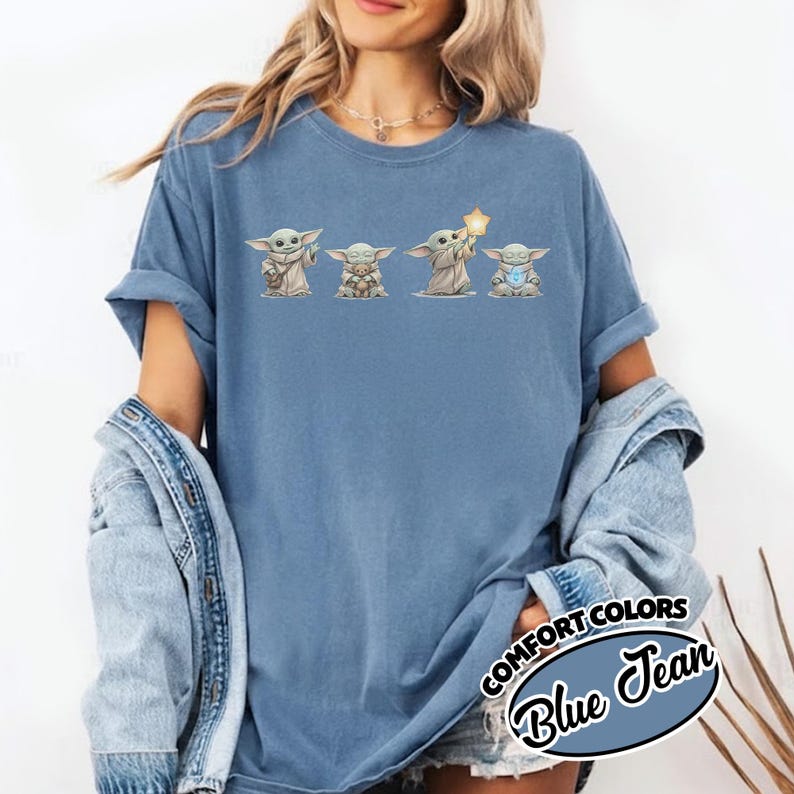 以下が含まれることがあります： グローグのキャラクターの4つのイラストが特徴のブルージーンズカラーのTシャツ。イラストは、さまざまなアイテムを持っているグローグを描いています。「COMFORT COLORS」と「Blue Jean」の文字がシャツの右下にプリントされています。