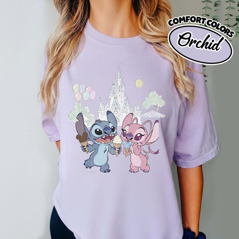 Puede incluir: Camiseta lila claro con un dise&ntilde;o de Stitch y Angel sosteniendo helados frente a un castillo. La camiseta tiene las palabras "Comfort Colors" y "Orchid" impresas.