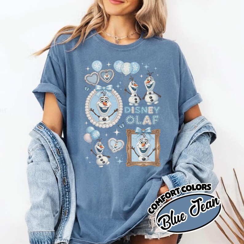 May include: Blue jean Comfort Colors t-shirt featuring Olaf from Disney's Frozen. The design includes Olaf images, balloons, and the text "Disney Olaf". The shirt has rolled-up sleeves.