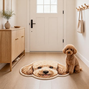 Peut inclure: Un tapis rond marron clair en forme de tête de caniche avec des oreilles marron foncé et un visage souriant, doté d'un poil texturé. Un petit caniche marron clair est assis à côté du tapis sur un parquet clair dans une entrée lumineuse.