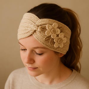 May include: A beige knitted headband with a twisted knot design. The headband is adorned with two beige and brown flower appliqués. The knitted texture is visible, and the headband appears to be made of a soft, warm material.