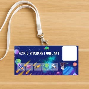 May include: A lanyard with a white strap and a metal clasp. The attached badge features a space-themed design with planets, rockets, and the text "FOR 5 STICKERS I WILL GET". Includes a blank white space.
