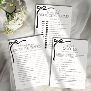 May include: Three white paper wedding game cards with black text and bow illustrations. The cards are titled Guess Who Bride or Groom, How Well Do You Know The Bride, and Movie Quotes, featuring lists of questions, lines for names, and scores.