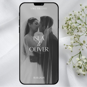 May include: Black and white wedding announcement on a smartphone screen. The image features a couple kissing under a veil, with the names "ISLA & OLIVER" and the date "10.10.2028" in elegant typography. The words "SAVE THE DATE" are at the top.