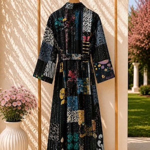 May include: A long-sleeved robe featuring a patchwork design with various colorful patterns on a dark base. The garment includes a matching tie belt at the waist and is constructed with visible vertical stitching throughout the fabric.
