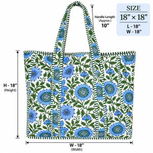 May include: A quilted tote bag with a white background and a blue floral pattern featuring green leaves. The bag measures 18 inches in height and 18 inches in width, with a handle length of approximately 10 inches. The edges are trimmed in green and white stripes.