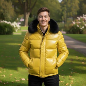 Può includere: Giacca trapuntata in pelle gialla con collo in pelliccia nera. La giacca ha una chiusura a zip e tasche. La persona indossa una camicia nera e pantaloni neri. Lo sfondo è un parco con erba verde e alberi.