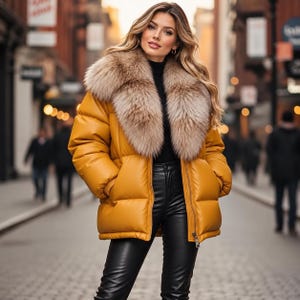 May include: A mustard yellow puffer jacket featuring a large, fluffy faux fur collar in shades of brown and beige. The jacket has a smooth, matte finish, long sleeves with ribbed cuffs, and a front zip fastening, worn over a black top and black trousers.