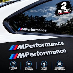 Op de afbeelding: Twee MPerformance vinylstickers met de iconische blauwe, paarse en rode schuine strepen gevolgd door witte tekst. De set bevat twee stuks, één aangebracht op een autoruit en één op een zwart oppervlak, met iconen die de duurzaamheid aangeven.