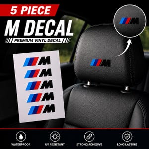 May include: A 5-piece M decal set featuring premium vinyl stickers with the blue, red, and black M logo. The sheet displays five individual decals, and a circular inset shows the decal applied to a black leather car headrest with text.