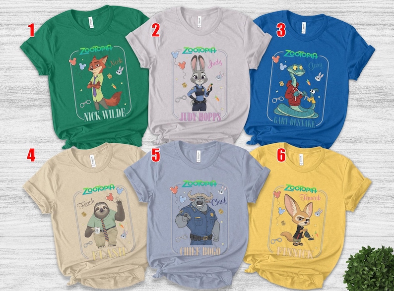 Puede incluir: Seis camisetas coloridas con personajes de la pel&iacute;cula animada "Zootr&oacute;polis". Cada camiseta muestra un personaje diferente, incluyendo a Nick Wilde, Judy Hopps, Gary, Flash, Chief Bogo y Finnick, con sus nombres impresos debajo.