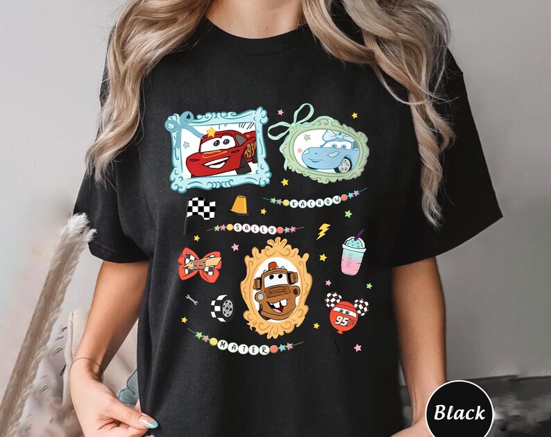 Puede incluir: Camiseta negra con personajes de coches de dibujos animados en marcos decorativos. El dise&ntilde;o incluye un coche rojo, un coche azul y un coche marr&oacute;n, adem&aacute;s de estrellas, una bandera a cuadros y un batido.