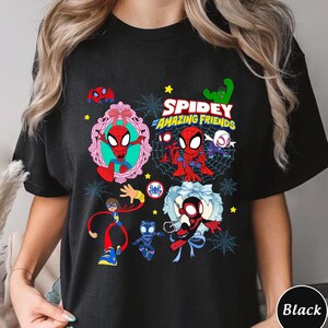 May include: Black t-shirt featuring a colorful graphic of Spider-Man and friends. The design includes the text "Spidey and His Amazing Friends" with various characters and spiderwebs. The shirt is a comfortable fit.