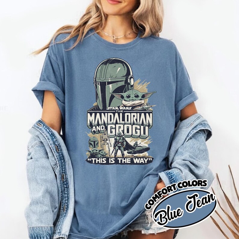Puede incluir: Camiseta azul Comfort Colors con un gr&aacute;fico de Star Wars con "The Mandalorian and Grogu". El dise&ntilde;o incluye el casco mandaloriano, Grogu y la frase "This is the Way".