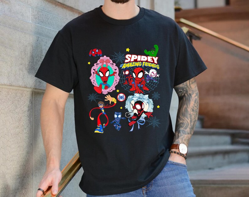 May include: Black t-shirt featuring a colorful graphic of Spider-Man and friends. The design includes the text "Spidey and His Amazing Friends" with various cartoon illustrations of the characters. The shirt is a crew neck style.