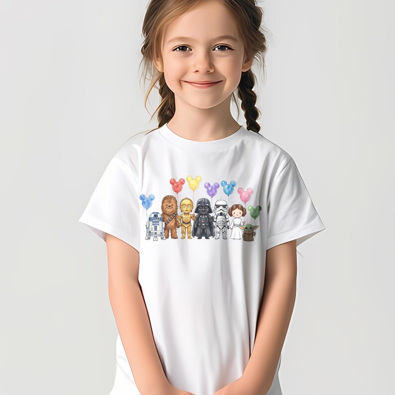 Op de afbeelding: Wit T-shirt met een kleurrijke illustratie van Star Wars-personages en Mickey Mouse-vormige ballonnen. Het ontwerp bevat R2-D2, Chewbacca, C-3PO, Darth Vader, een Stormtrooper, Princess Leia en Grogu.
