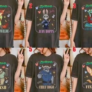 Puede incluir: Camisetas de color gris oscuro con personajes de la pel&iacute;cula animada Zootr&oacute;polis. Cada camiseta muestra un personaje diferente: Nick Wilde, Judy Hopps, Gary, Flash, Chief Bogo y Finnick, con sus nombres debajo. El logo de Zootr&oacute;polis est&aacute; en la parte superior.