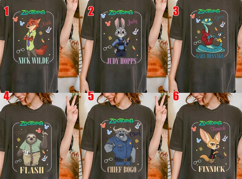 Puede incluir: Camisetas de color gris oscuro con personajes de la pel&iacute;cula animada Zootr&oacute;polis. Cada camiseta muestra un personaje diferente: Nick Wilde, Judy Hopps, Gary, Flash, Chief Bogo y Finnick, con sus nombres debajo. El logo de Zootr&oacute;polis est&aacute; en la parte superior.