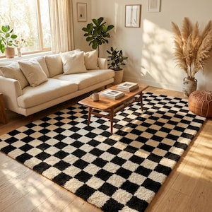 May include: A living room scene featuring a cream-colored sofa, wooden coffee table, and a black and white checkered rug. The room is well-lit with natural light, and decorative plants and a woven light fixture add to the cozy atmosphere.