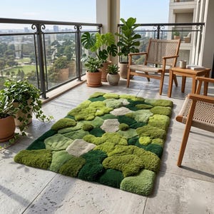 May include: A rectangular rug with a textured, moss-like design in shades of green and off-white. The rug is placed on a patio with wooden furniture and potted plants. The rug's dimensions are approximately 60 inches by 40 inches.