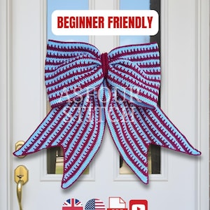 May include: A large, handmade crochet bow in burgundy and light blue stripes, displayed on a white door. The bow is a decorative item, with the text "BEGINNER FRIENDLY" in a red banner above it.