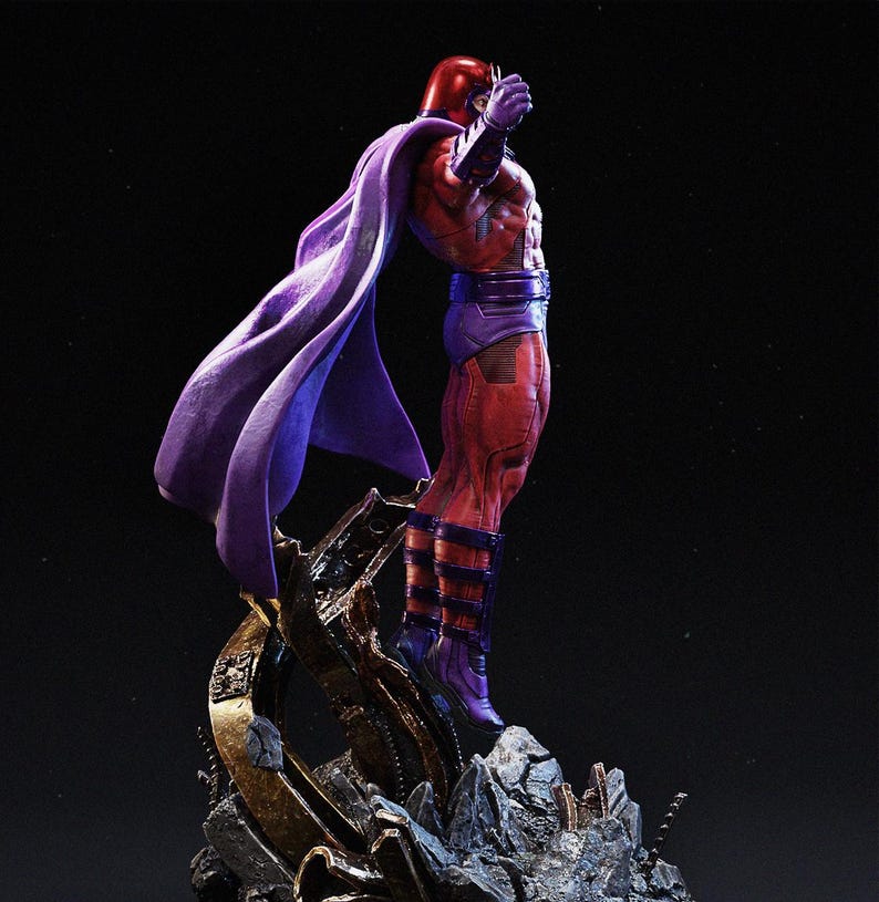 Op de afbeelding: Gedetailleerd beeldje van een superheld in een dynamische pose. Het figuur is gekleed in een rood en paars pak met bijpassende helm en cape. De basis is een gedetailleerde, rotsachtige structuur met metalen accenten.