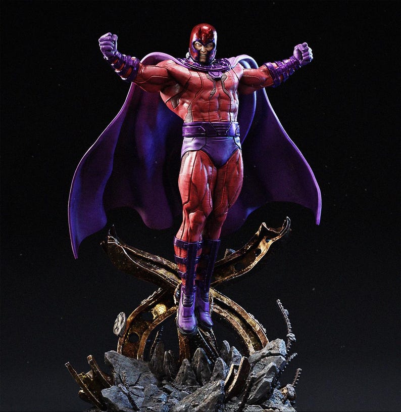 Op de afbeelding: Een gedetailleerd beeldje van Magneto, een stripboekpersonage, in een dynamische pose. Het figuur is gekleed in een rood en paars kostuum met een helm, cape en laarzen. Het beeld is gemonteerd op een rotsachtige, metalen basis, met de armen geheven.