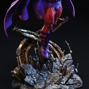 Op de afbeelding: Een gedetailleerd beeld van een superheld in een dynamische pose. De figuur is gekleed in een paarse cape, rood-paarse laarzen en een paars bodysuit. Het beeld rust op een rotsachtige, metalen basis met gouden accenten, met ingewikkelde details.