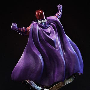 Op de afbeelding: Een beeld van een personage in een paarse cape en helm. De figuur poseert met opgeheven armen en toont een gedetailleerd ontwerp. De helm is dieprood en de cape heeft een vloeiend, getextureerd uiterlijk. Het beeld staat op een donkere achtergrond.