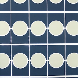 May include: Abstract geometric pattern. Navy blue squares are arranged in a grid, each containing an off-white circle. White lines connect the circles, creating a repeating design, ideal for wallpaper.