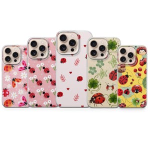 May include: A collection of five phone cases with various ladybug-themed designs. The cases feature different patterns, including ladybugs with flowers, hearts, clovers, and stars. The color palette includes pink, white, and yellow.
