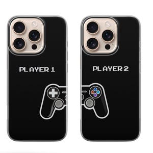 May include: Two black phone cases with a white outline of a game controller. One case says "PLAYER 1" and the other says "PLAYER 2". The controller on the "PLAYER 1" case has a plus sign. The controller on the "PLAYER 2" case has colored buttons.