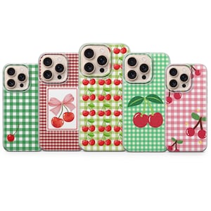 May include: Five phone cases with cherry designs. The cases display patterns like gingham and cherry illustrations. Colours include green, red, and pink. Each case has a camera cutout and a protective design.