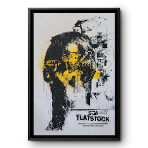 May include: Framed art print featuring a black and yellow abstract design. The artwork includes a stylized figure with splattered paint effects. The text "SON FLATSTOCK" is visible, along with event details.