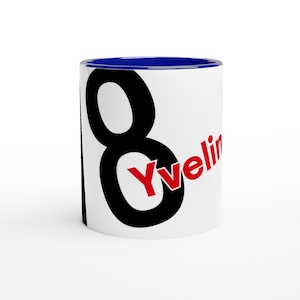 May include: White ceramic mug with a blue interior rim. The mug features a large black number 8, with the name "Yveline" in red, diagonally across the number. The mug is designed for hot beverages.