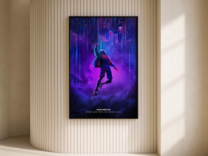 May include: A framed poster featuring a dynamic illustration from "Spider-Man: Into the Spider-Verse." The artwork depicts a figure in mid-air against a vibrant, purple and blue cityscape backdrop. The poster is displayed on a beige wall.