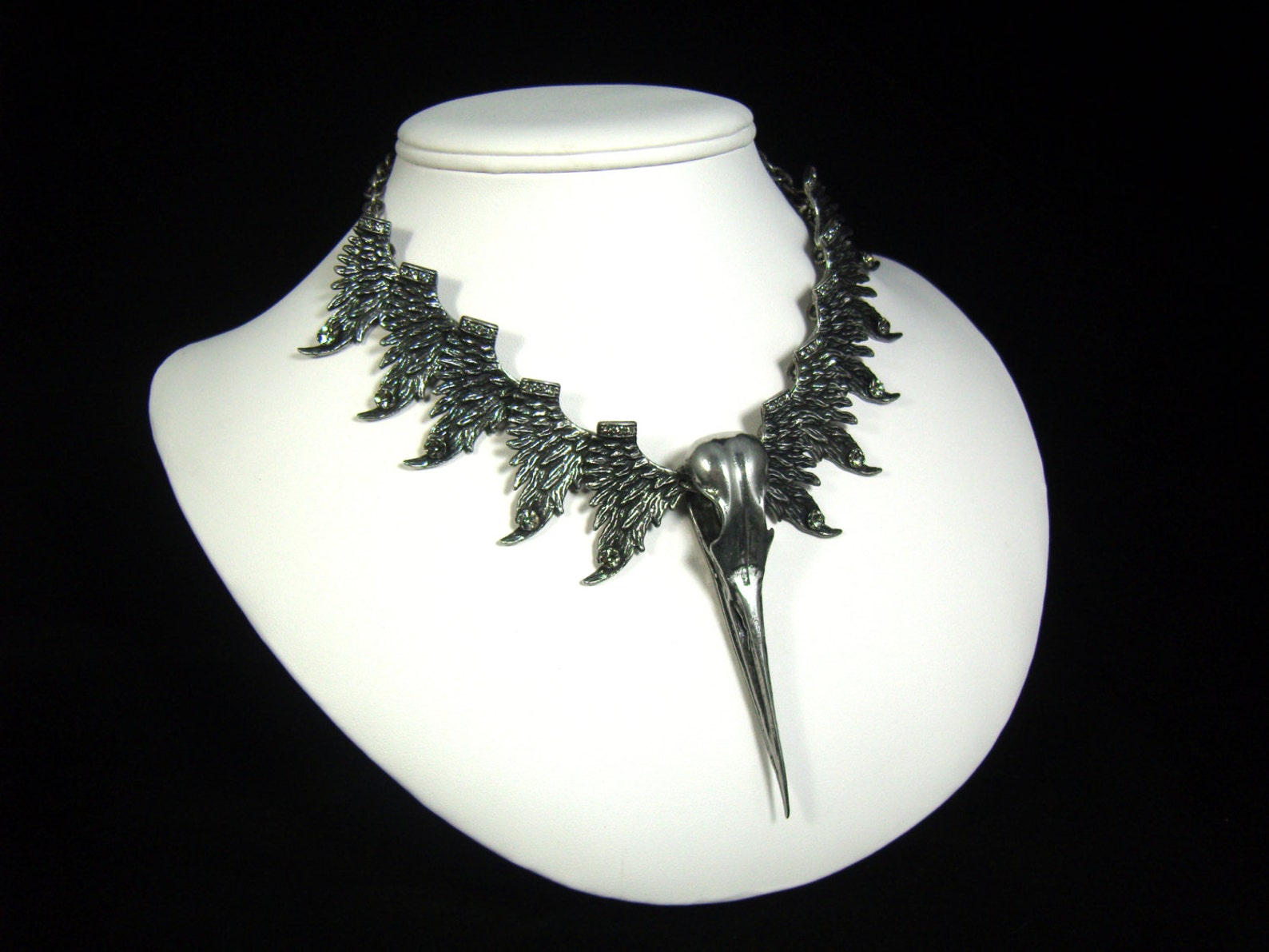 Gothic bird skull necklace with winged pewter design and long central beak pendant.