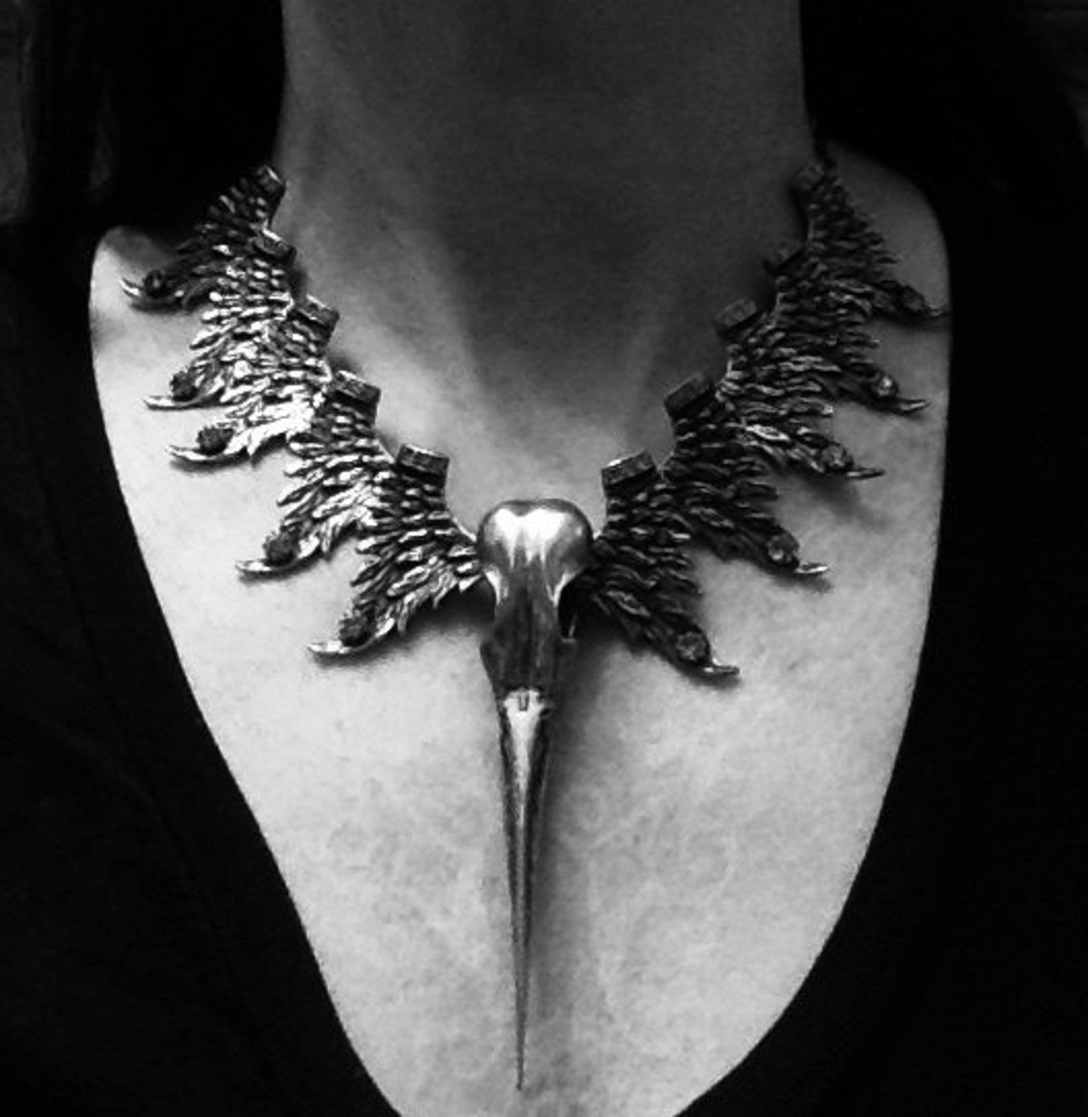 Phoenix necklace worn on black top, featuring bird skull centerpiece and spiked wing collar.